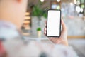 Back view close up of a person using smartphone mockup blank screen in home interior. Mock up white empty mobile phone at home Royalty Free Stock Photo