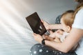 Back view.Close-up of tablet computer in hands of mother sitting with baby. Toddler girl looking at screen of smartphone Royalty Free Stock Photo