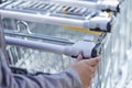 Back view closeup with a selective focus of a girl putting a coin into shopping cart outside a supermarket Royalty Free Stock Photo