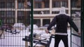 Back view confident Caucasian man and woman entering sports ground outdoors on winter day. Motivated fit couple talking