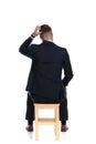 Back view of confused businessman scratching his head and sitting Royalty Free Stock Photo
