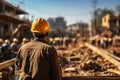 Back view of a construction worker wearing yellow safety helmet and a uniform at construction site. Housebuilder in sturdy work Royalty Free Stock Photo