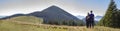 Back view of couple athletic boy and blond girl standing together embraced enjoying breathtaking view of magnificent Carpathian m Royalty Free Stock Photo