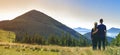 Back view of couple athletic boy and blond girl standing together embraced enjoying breathtaking view of magnificent Carpathian mo Royalty Free Stock Photo