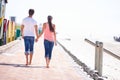 Back view, couple holding hands and walking on beach, romantic date and commitment with trust. Love, care and people Royalty Free Stock Photo