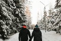 Back view of couple in love holding hands on joint romantic walk in nature park on winter day. Royalty Free Stock Photo