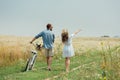 back view of couple with retro bicycle in summer field Royalty Free Stock Photo