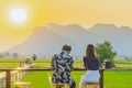 Back view of couple sit for resting and waiting for time to take photos of the sunset on the farmer`s balcony