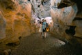 Back view. Couple of tourists exploring the cave. The interior of the cave. Touristic hiking route. Concept of excursions and