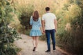 Back view couple walking away in the field, view of couple holding hands Royalty Free Stock Photo