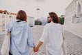 Back view of couple hugging and walking on Lisbon street, enjoying sightseeing outdoors Royalty Free Stock Photo