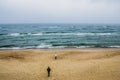 back view of couple walking on seashore and looking at wavy sea, Curonian