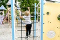 Back view cute adorable caucasian blond little toddler boy kid climbing rope ladder at modern playground.Outdoors children street Royalty Free Stock Photo