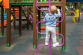 Back view cute adorable caucasian blond little toddler boy kid having fun enjoy climbing metal stairs at children modern