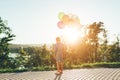 Cute girl holding colorful balloons in the city park dreaming Royalty Free Stock Photo