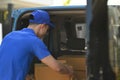 Back view of delivery men unloading cardboard boxes from cargo van. Delivery service, delivery home and shipping concept Royalty Free Stock Photo