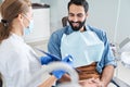 Back view of the dentist in protective mask examining her male patient Royalty Free Stock Photo