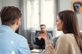 Depressed young couple of man and woman speaking with psychologist on therapy session in modern office. Bad Royalty Free Stock Photo