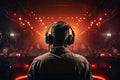 Back view of a disc jockey with headphones in front of the stage lights, rear view DJ with headphones at a nightclub party, AI Royalty Free Stock Photo