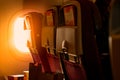 Back view of economy seat with paper brochure insert in box over plastic airplane tray table . Sunlight passing through the