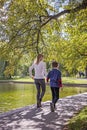 Back view of mother and boy walking in city park in Boston