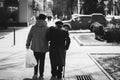 Back view of elder couple walking in the street.