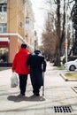 Back view of elder couple walking in the street.