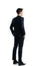 back view of elegant young man holding hands in pockets and standing Royalty Free Stock Photo