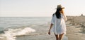 back view without face Happy traveler woman in white shirt enjoys her tropical beach vacation walks along the ocean Royalty Free Stock Photo
