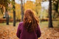 Back view faceless portrait of red-haired girl with fall leaves in hair. Autumn Portrait of happy woman Royalty Free Stock Photo