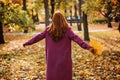 Back view faceless portrait of red-haired girl with fall leaves in hand. Autumn Portrait of happy woman Royalty Free Stock Photo