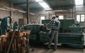 Back view. Factory male worker in uniform is indoors