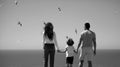 Back view of family on the beach on sky. People having fun on summer vacation. Father, mother and child holding hands Royalty Free Stock Photo