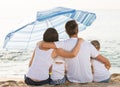 Back view on family of four sitting on beach Royalty Free Stock Photo