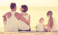 Back view on family of four sitting on beach Royalty Free Stock Photo