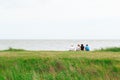 Back view of a family sitting on Minsmere beach in the UK