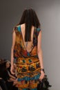 Back view of fashion model in silk dress walking on podium during fashion week