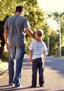 Back view, father and child walking on street together for bonding, support and love on vacation or holiday in summer