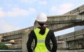 Back view of female construction worker against expressway background