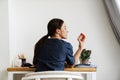 The back view of female doctor sitting at table looking at jar of pills Royalty Free Stock Photo