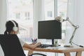 Back view of female employee speak talk on video call online briefing, woman worker have Webcam group conference with coworkers on Royalty Free Stock Photo