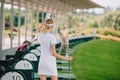 back view of female golfer with golf club greeting friend