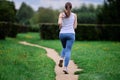 Back view of female runner exercising in public park in summer. Royalty Free Stock Photo