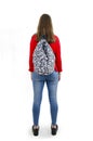 Back view of female student. Adorable teenage girl with backpack standing looking at wall. Royalty Free Stock Photo