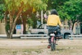 Back view of female teacher rides bicycle to teach students