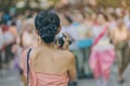 Back view of female in Thai dress take a photo of a Thai dance parade in Songkran festival