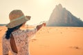 Back view female tourist stand watch point finger to seven pillars of wisdom monument in wadi rum desert-famous nature reserve in Royalty Free Stock Photo