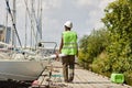 Back view female worker wearing hardhat walking in yacht docks