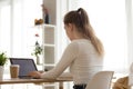 Focused girl typing at laptop working from home