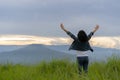 Back view. Freedom traveler teenage standing with raised arms and enjoying blue sky at sunset beautiful. Phu Pa PO or Fuji Loei of